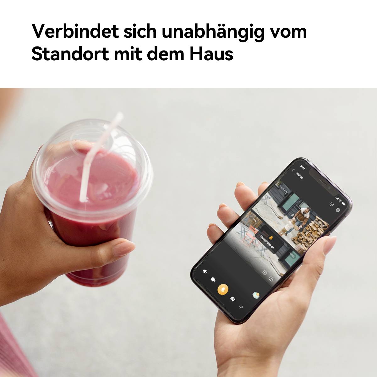 Osoba trzyma smartfon wyświetlający aplikację do monitoringu domu, stojąc obok napoju, co ilustruje mobilną kontrolę domu.