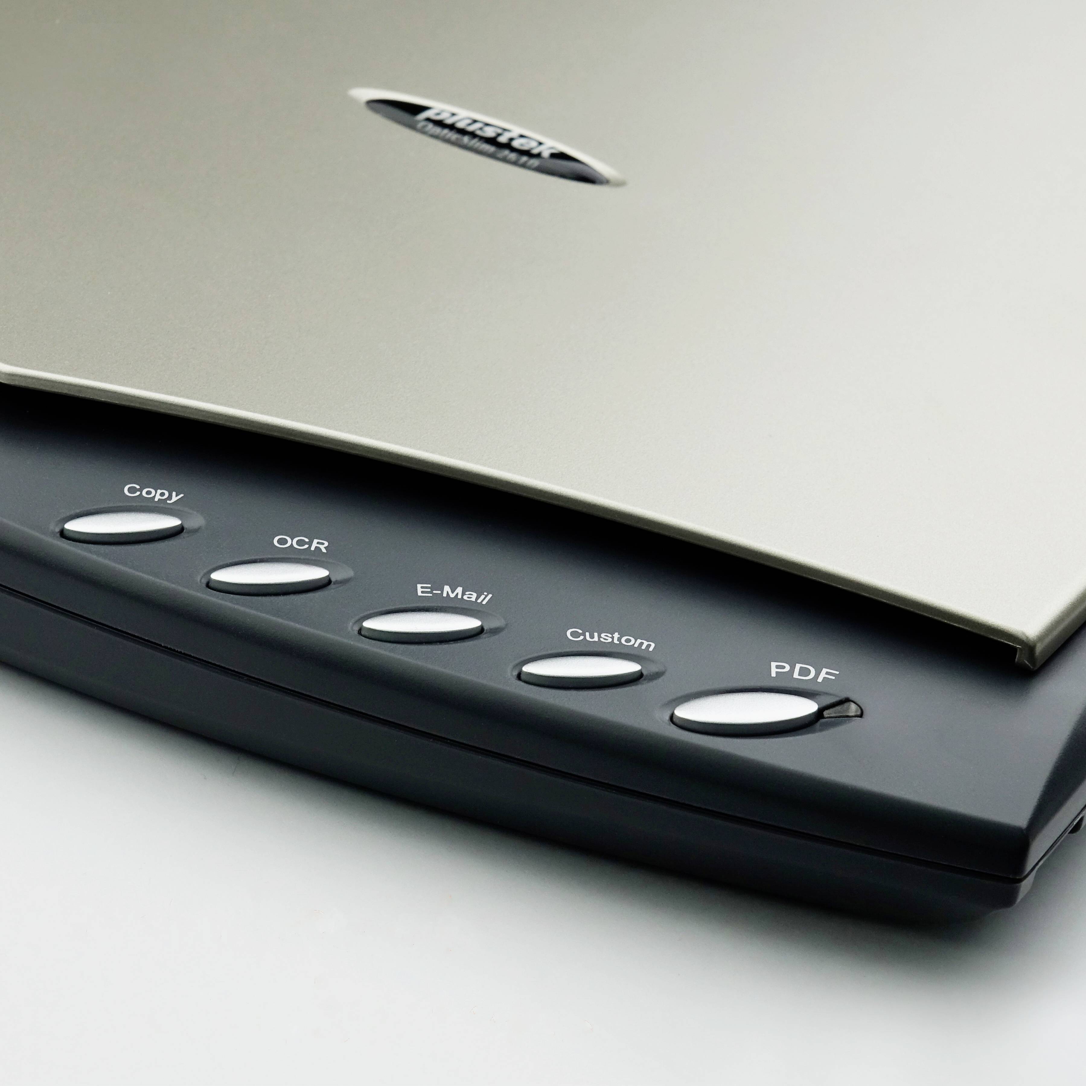 Płaski skaner z pięcioma przyciskami: 'Kopiuj', 'OCR', 'E-mail', 'Własny', 'PDF'. Nazwa marki widoczna na górze skanera.