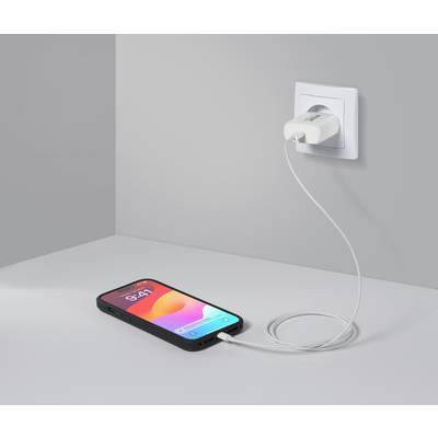 Smartfon ładuje się przez kabel podłączony do gniazdka elektrycznego. Wyświetlacz pokazuje godzinę 9:41 oraz kolorową grafikę w tle.