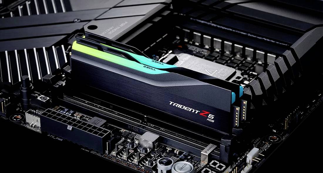 Zbliżenie modułu pamięci RAM Trident Z5 RGB, zainstalowanego na płycie głównej komputera, otoczonego różnymi elementami elektronicznymi.