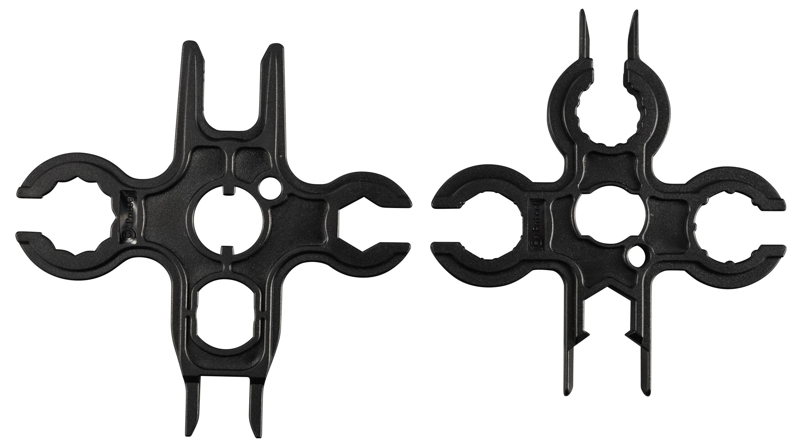 Dwa czarne plastikowe klipsy obok siebie, ukształtowane na kształt kół zębatych. Posiadają kilka otworów do mocowania.