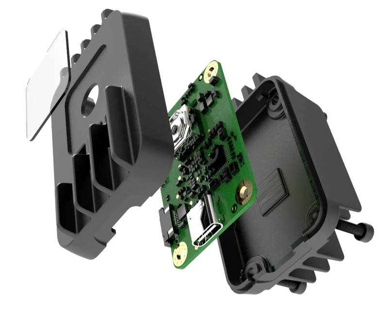 Widok rozłożony urządzenia elektronicznego. Przedstawia obudowę, płytkę drukowaną z obwodami i złączami. Prezentuje budowę techniczną.