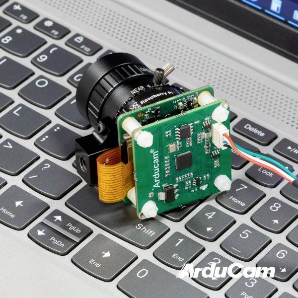 Kamera ArduCam podłączona do Raspberry Pi leży na klawiaturze laptopa.