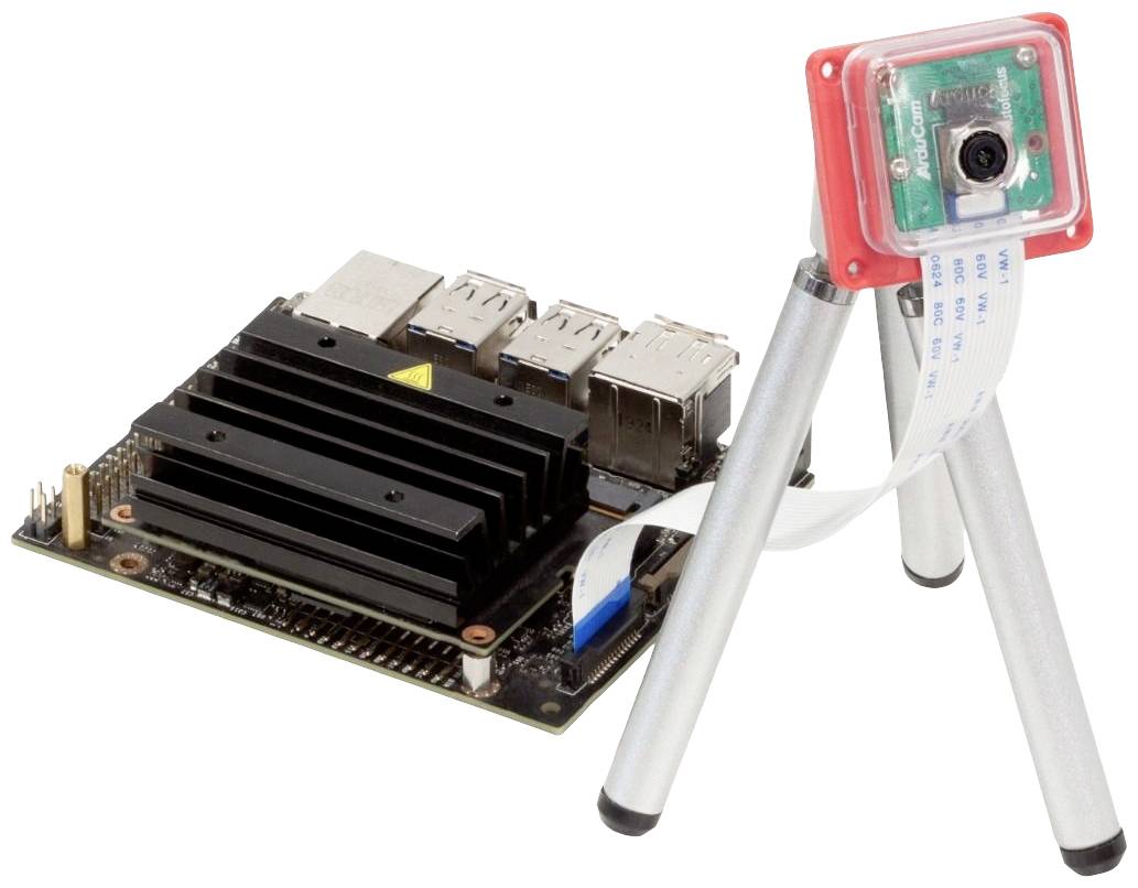 Mały komputer z radiatorem i czterema portami USB obok kamery na statywie, połączony przewodem.