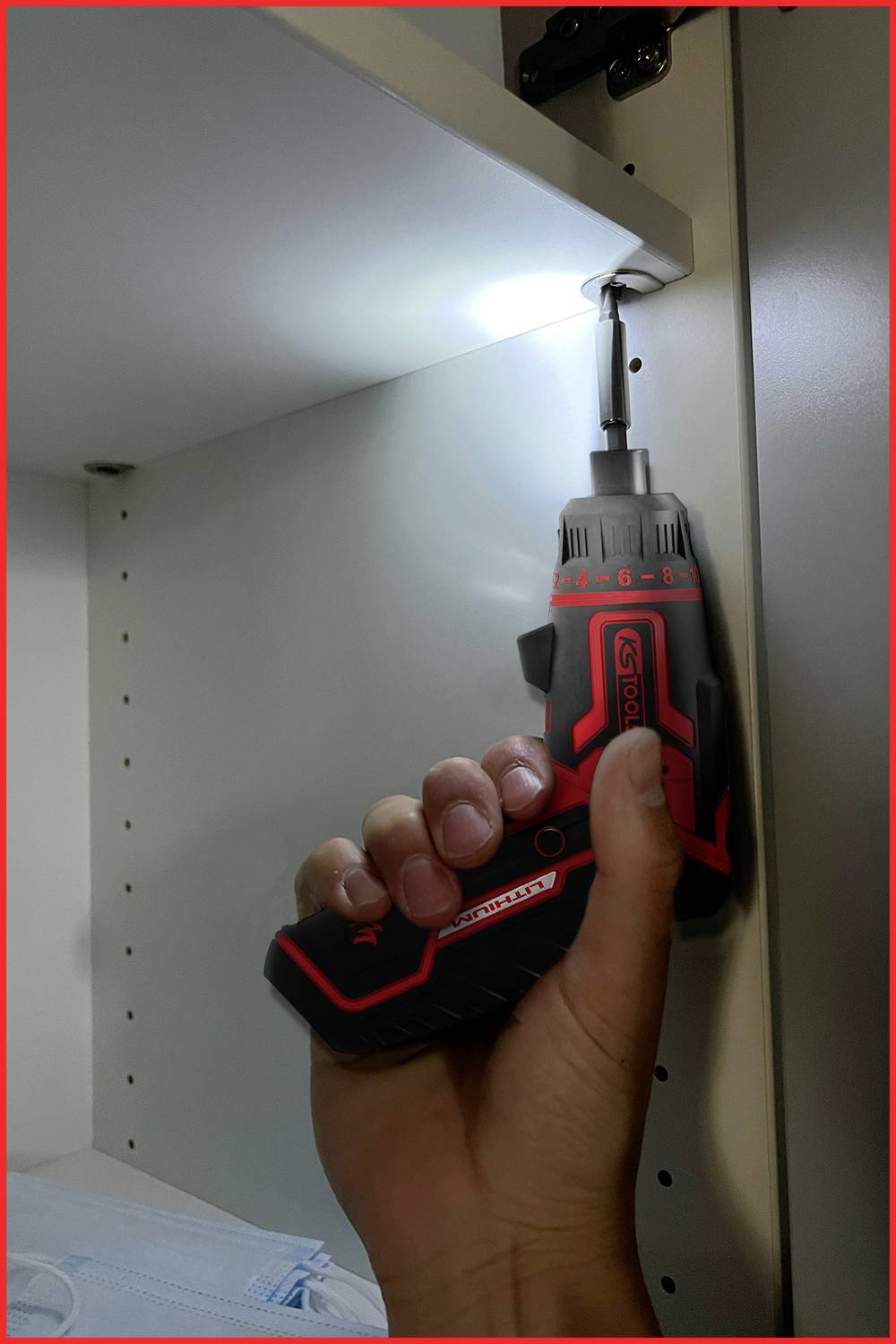 Akumulatorowy wkrętak jest używany do wkręcenia śruby w zawias białej półki.