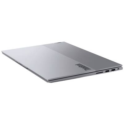 Szary, zamknięty laptop, widziany z boku, prezentuje lekko zaokrąglone krawędzie i kilka portów przyłączeniowych.