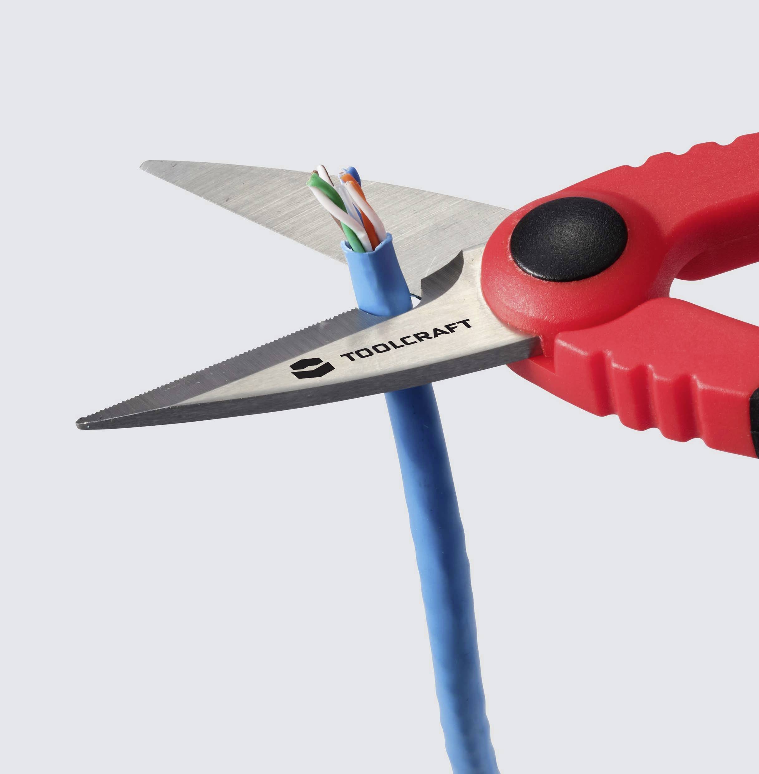 Czerwone cęgi do cięcia kabli przecinają niebieski kabel zawierający w środku kilka kolorowych przewodów.