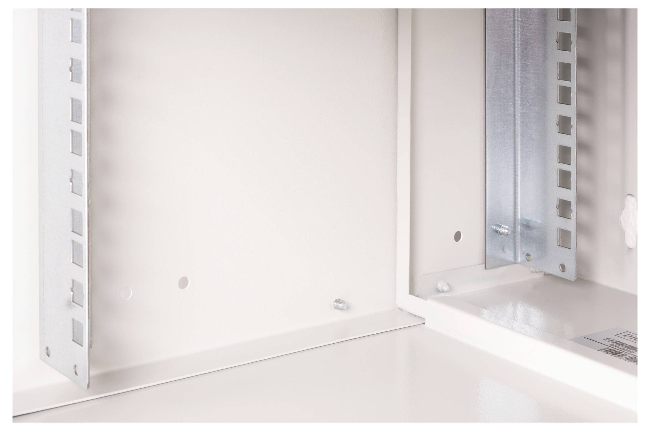 Wnętrze białej obudowy stalowej z wzmocnieniami metalowymi po bokach. Prezentuje solidną konstrukcję i stabilność obudowy.