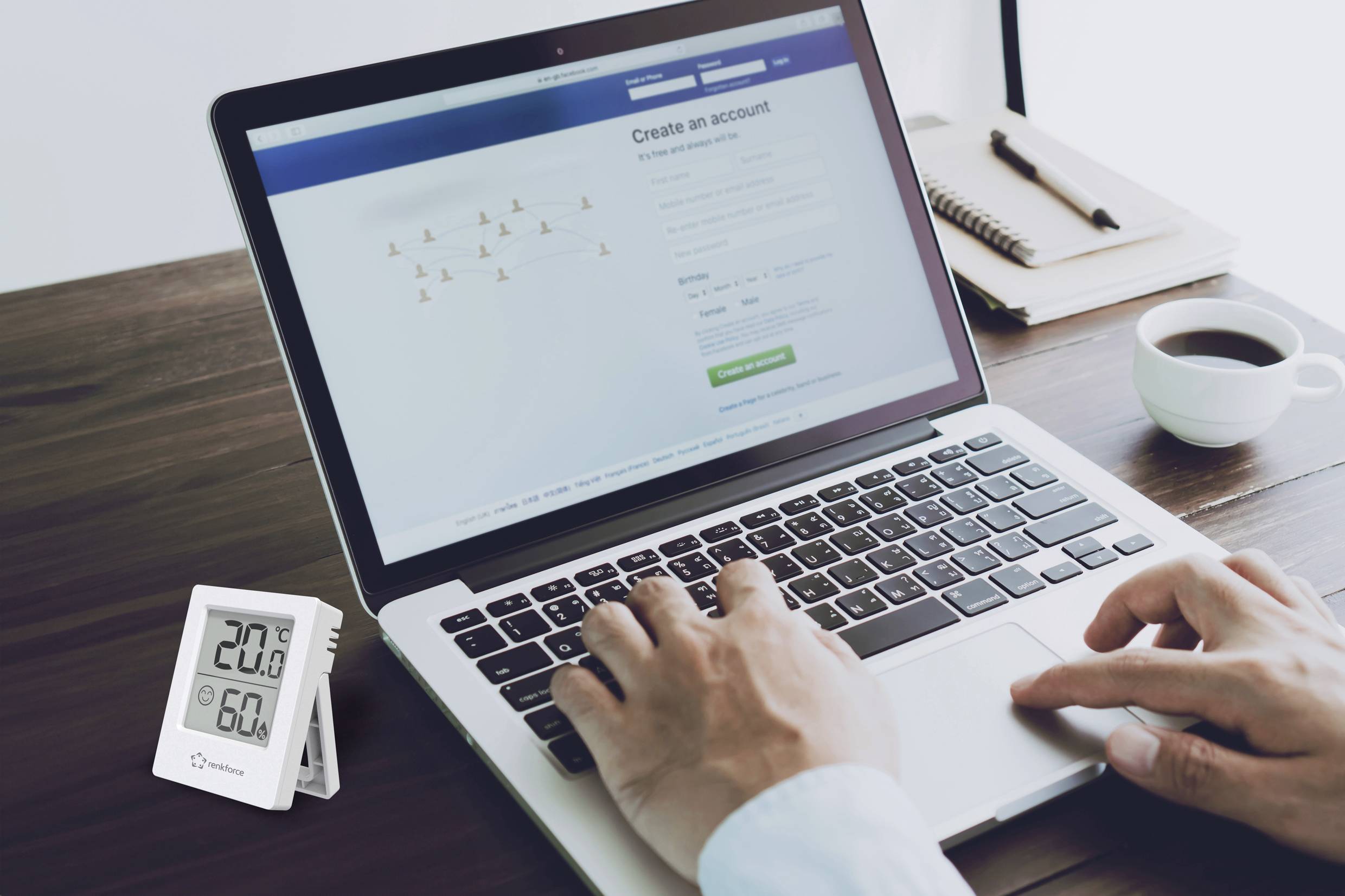 Osoba wpisuje dane na laptopie z otwartą stroną rejestracyjną. Obok znajduje się termometr wskazujący 20,8°C i 60% wilgotności powietrza.