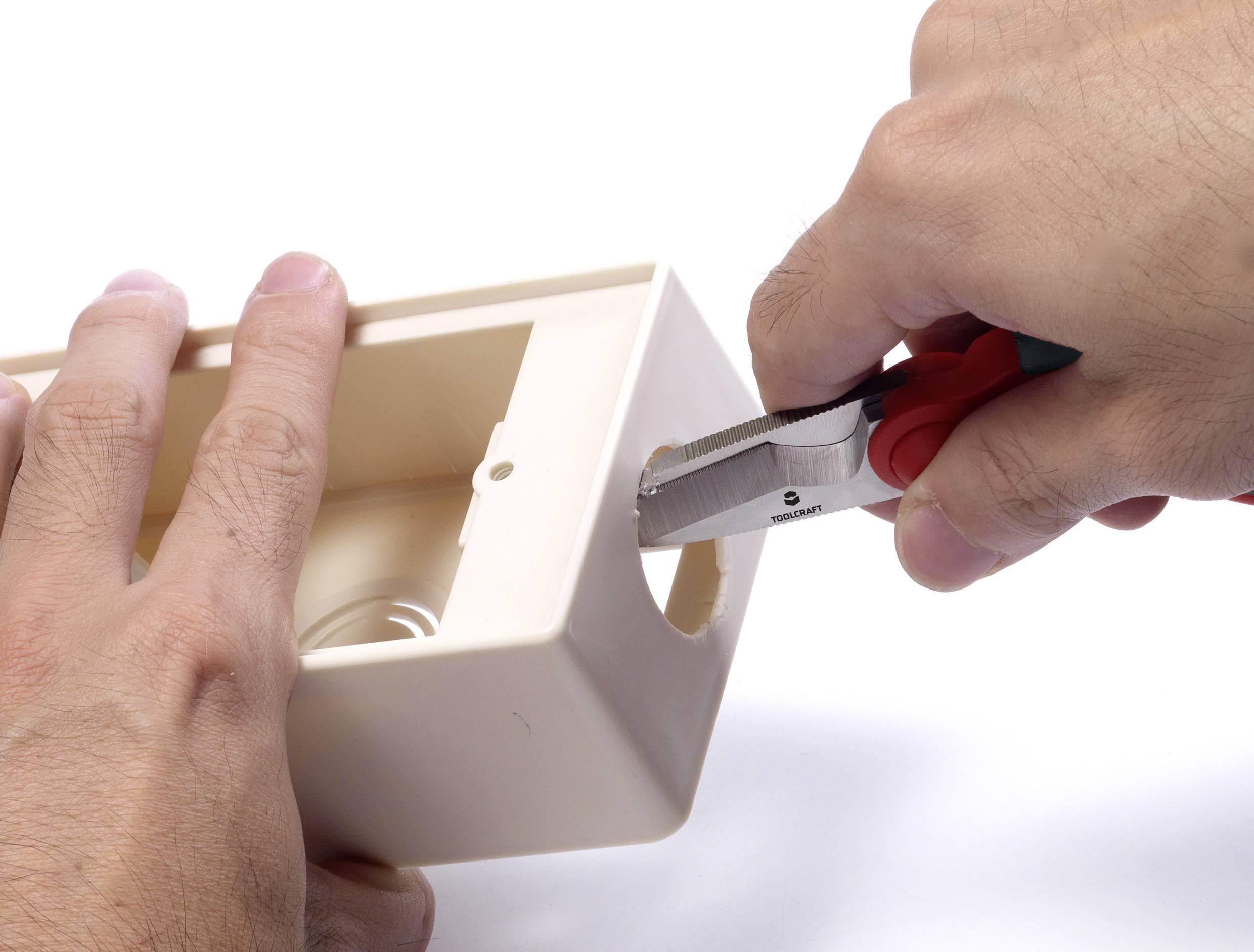 Osoba wycina dziurę w obudowie z tworzywa sztucznego za pomocą obcinaka bocznego.