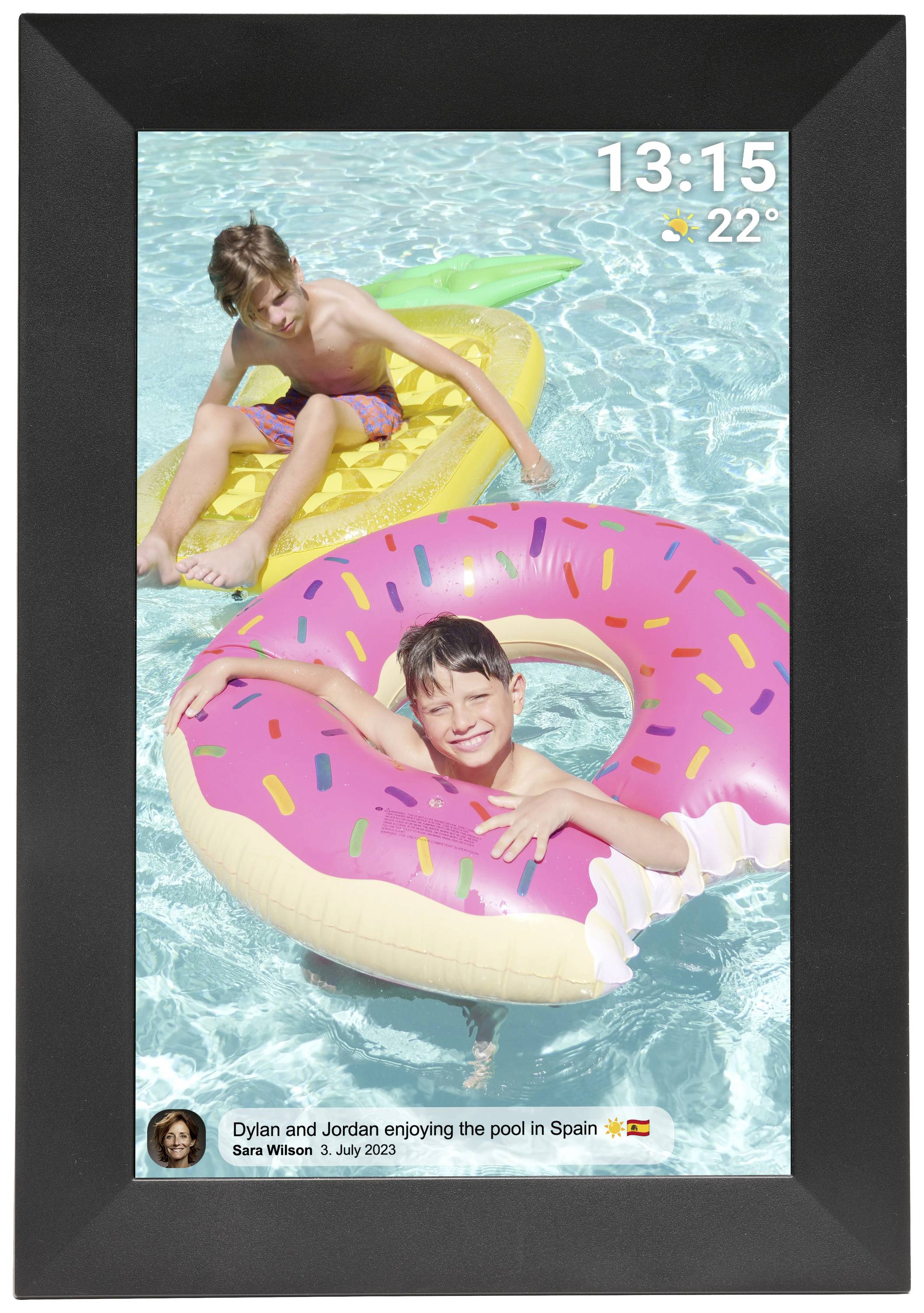 Dwoje dzieci bawi się w basenie, pływając na dmuchanych kołach ratunkowych w kształcie pączka i ananasa. Godzina: 13:15; Temperatura: 22°C.