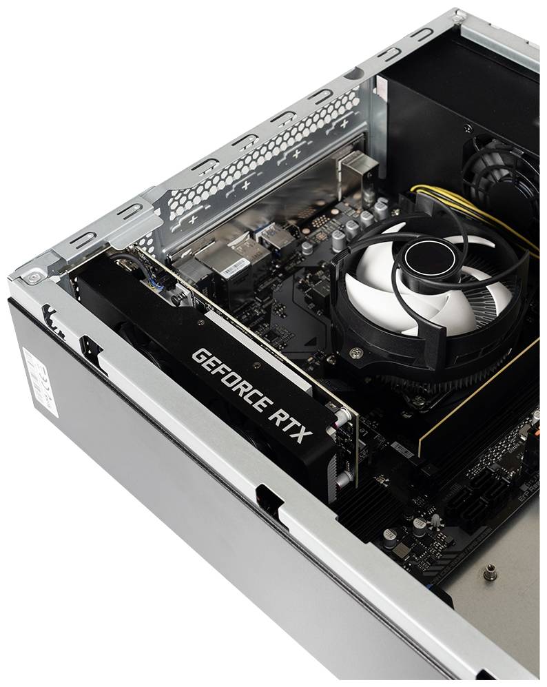 Otwarta obudowa komputera z kartą graficzną 'GeForce RTX' obok dużego radiatora procesora we wnętrzu.