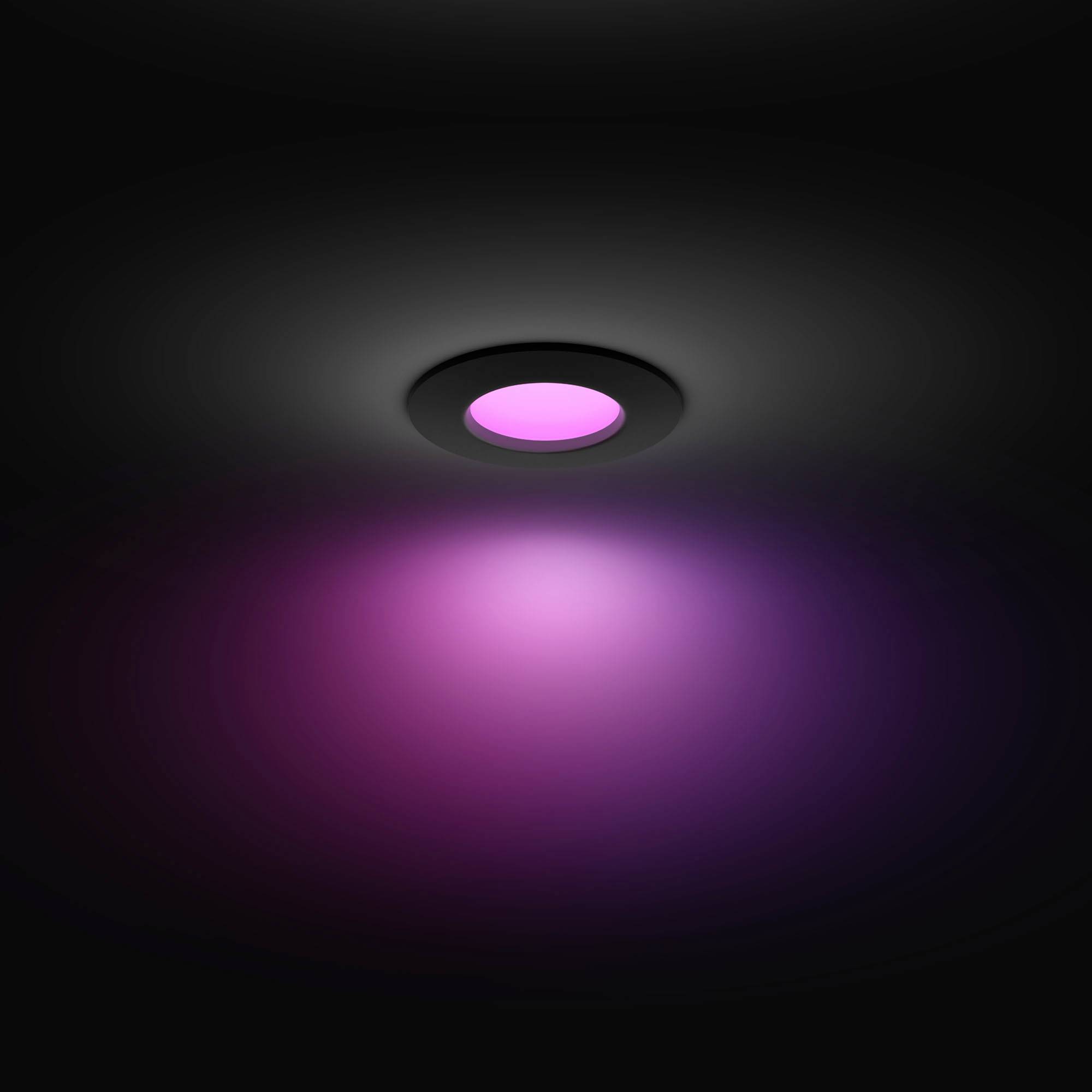 Okrągła lampa na suficie emituje delikatne, fioletowe światło, które oświetla pomieszczenie ciepłym, uspokajającym blaskiem.