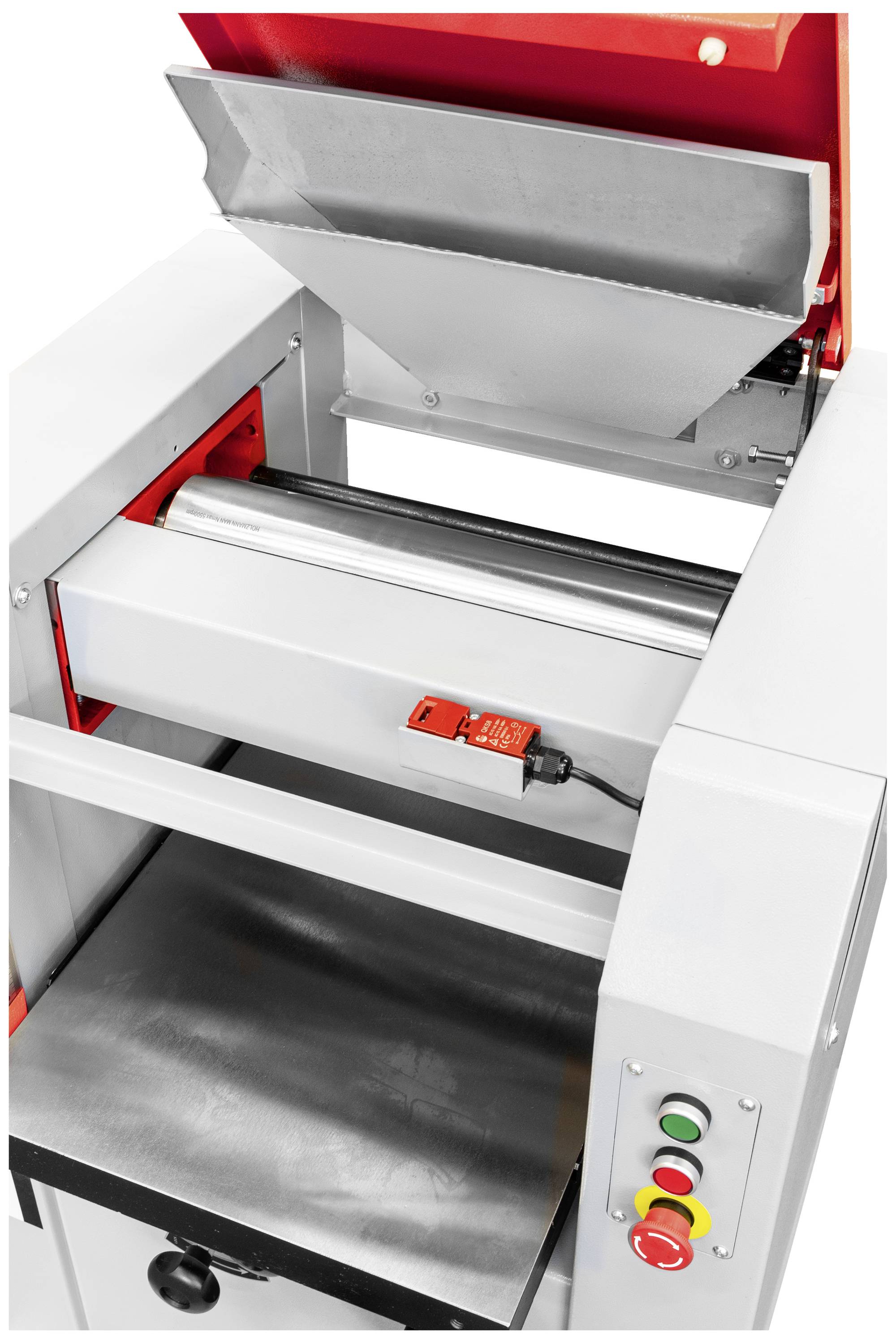 Przemysłowa maszyna z otwartą komorą, w odcieniach czerwieni i szarości, z elementami sterującymi po stronie. Wyraźny nacisk na funkcjonalność.