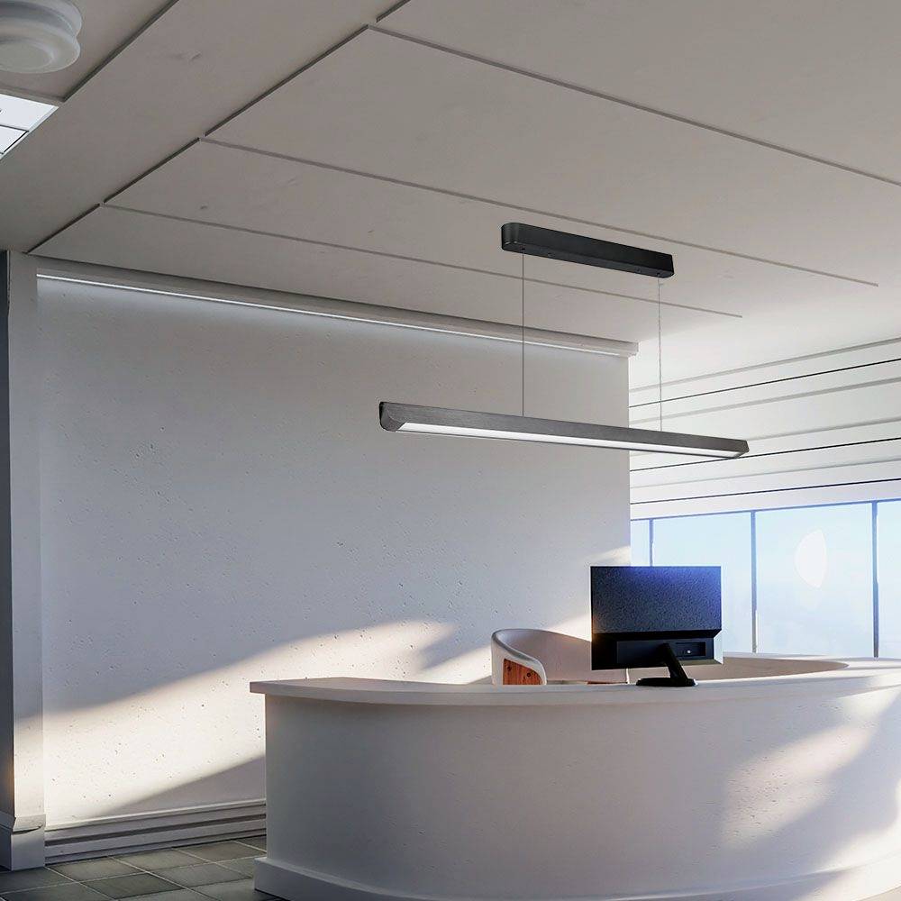 Nowoczesne biuro z zakrzywionym ladą recepcyjną i ekranem komputerowym, otoczone obfitością naturalnego światła.