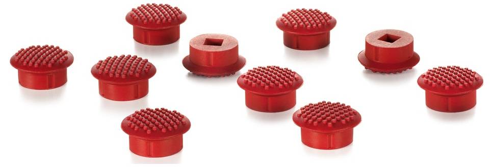 Czerwone guziki pisaków z teksturowaną powierzchnią, ułożone pod różnymi kątami.