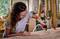 Kobieta w okularach ochronnych szlifuje deskę drewnianą szlifierką w warsztacie.