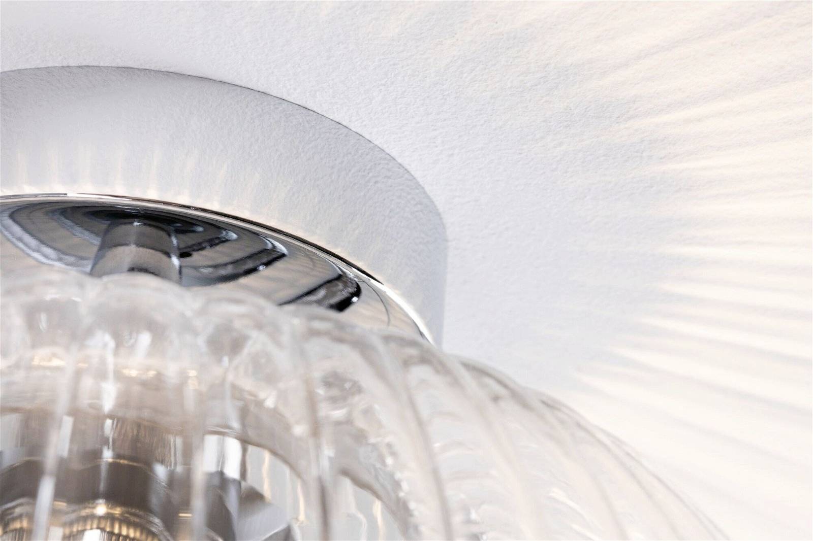 Lampa sufitowa ze szkłem żłobionym, która rzuca miękkie światło o promieniście rozchodzącym się wzorze na sufit. Nowoczesny design.