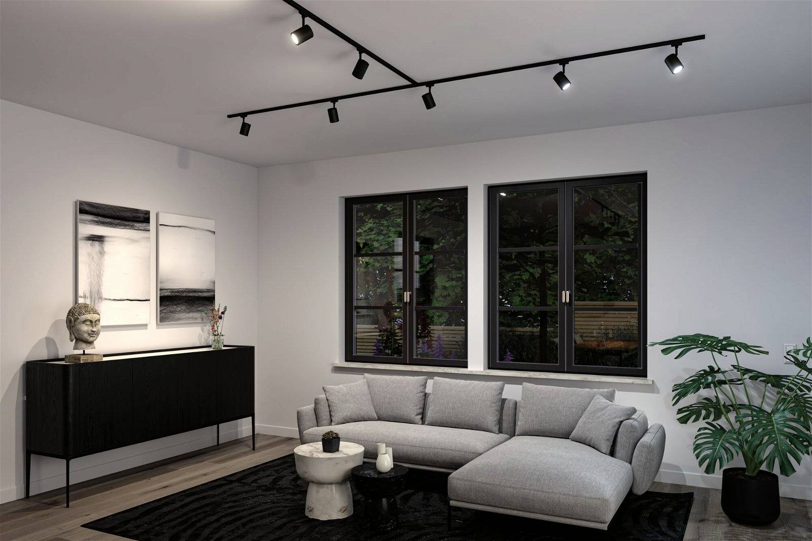 Salon z szarą sofą i stolikiem kawowym na czarnym dywanie. Na ścianie czarno-biała grafika, obok duże okno.