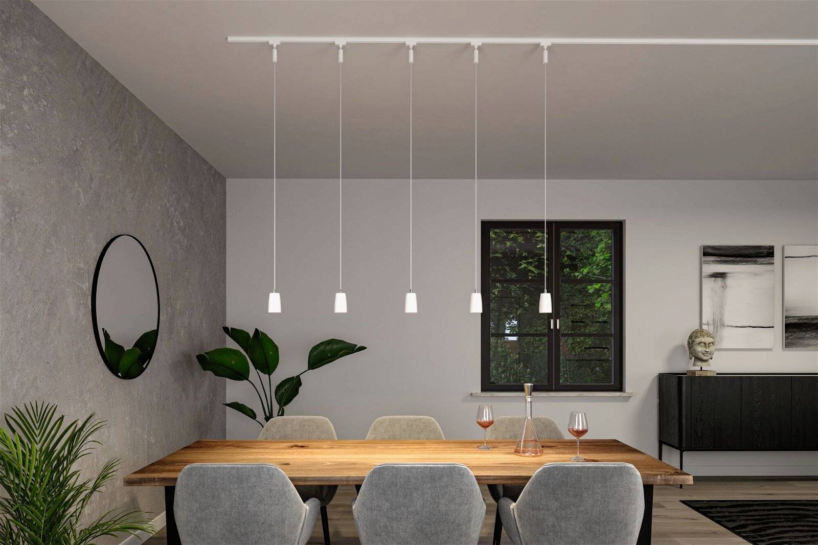 Jadalnia z drewnianym stołem, otoczonym sześcioma szarymi krzesłami. Wiszące lampy nad stołem, rośliny i obrazy na ścianach.