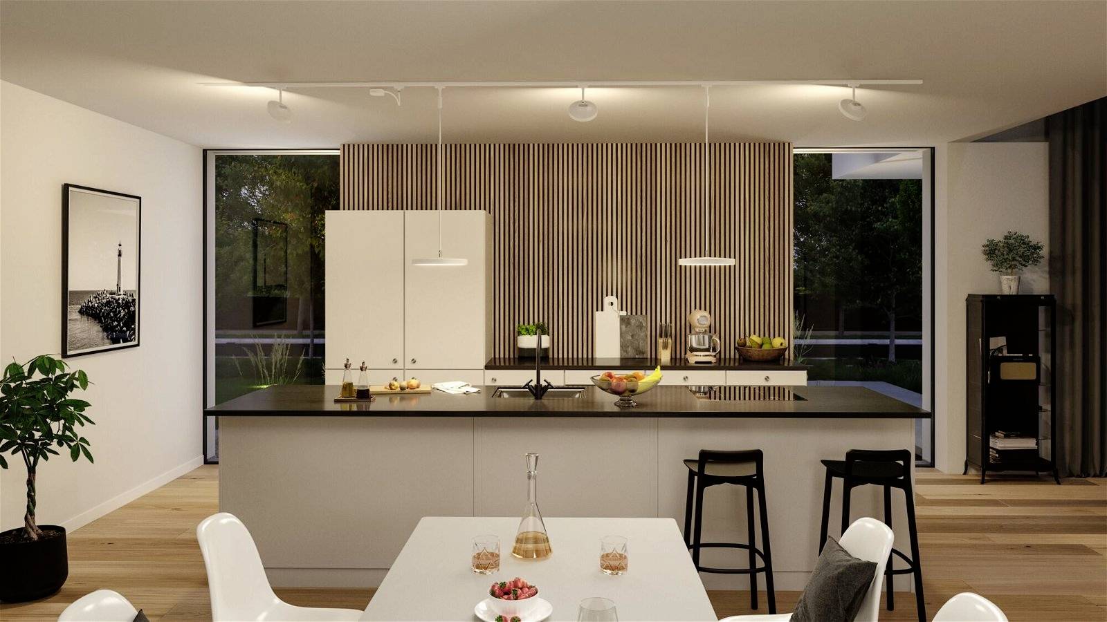 Nowoczesna kuchnia z wyspą kuchenną, białymi szafkami i ciemnym blatem. Na środku stoją miska z owocami i karafka z wodą.