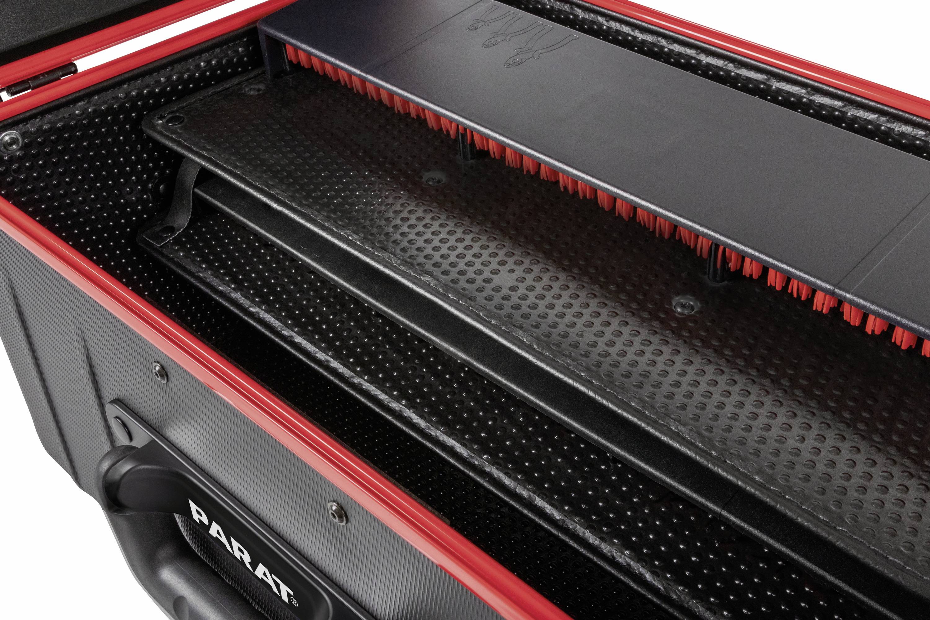 Ciasne ujęcie wnętrza otwartej walizki narzędziowej z czerwonymi krawędziami, widoczne otwarte przegródki.