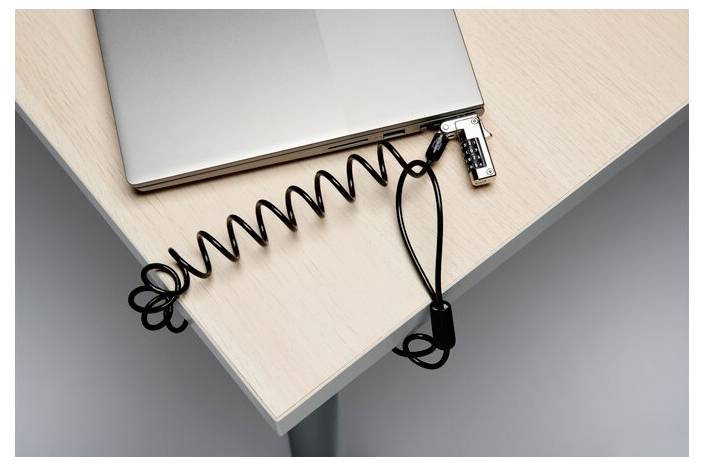 Laptop zabezpieczony na stole za pomocą linki zabezpieczającej z zamkiem spiralnym.