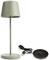 Zielona lampa stołowa z okrągłą podstawą oraz ładowarką USB obok niej. Minimalistyczny design, idealny do biurka lub stolika nocnego.