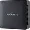Czarny, kompaktowy komputer firmy Gigabyte stojący na stole. Obudowa jest prosta i widoczne jest na niej logo Gigabyte.