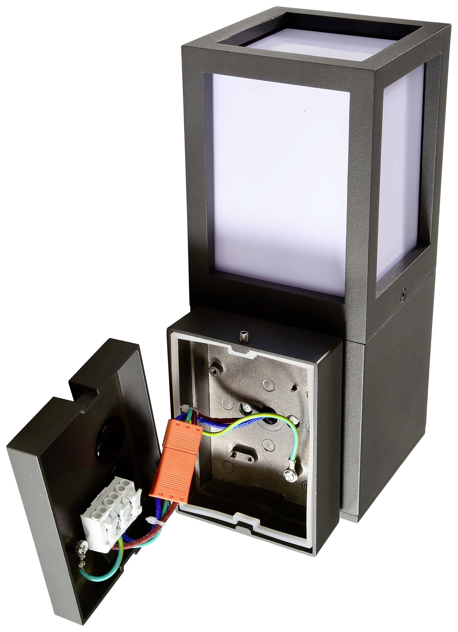 Czarna lampa zewnętrzna o prostokątnym kształcie, z odkrytą pokrywą, ujawnia wewnętrzne przewody i złącza.