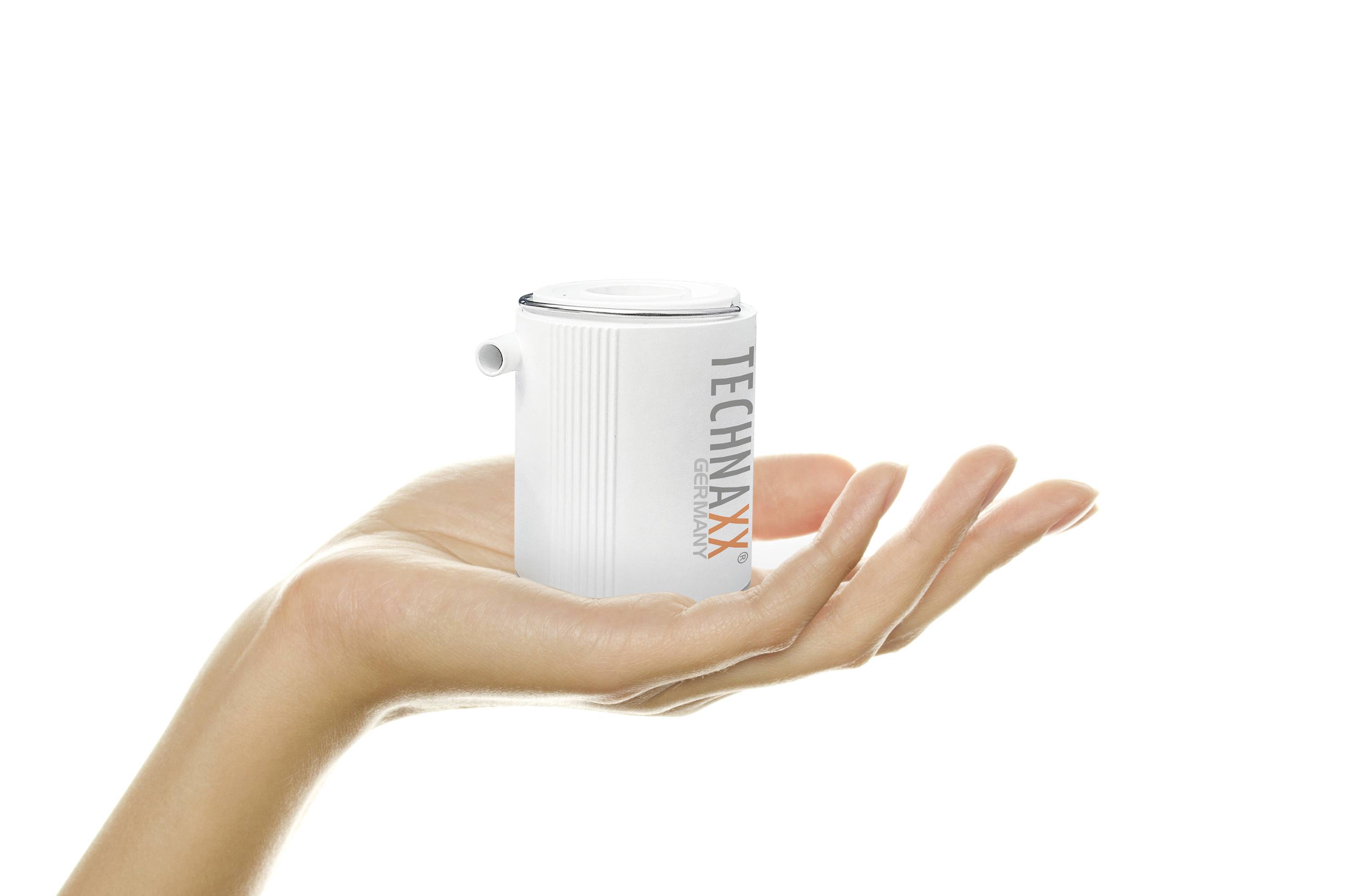 Dłoń trzyma mały biały przenośny głośnik z napisem 'TECHNAXX'.