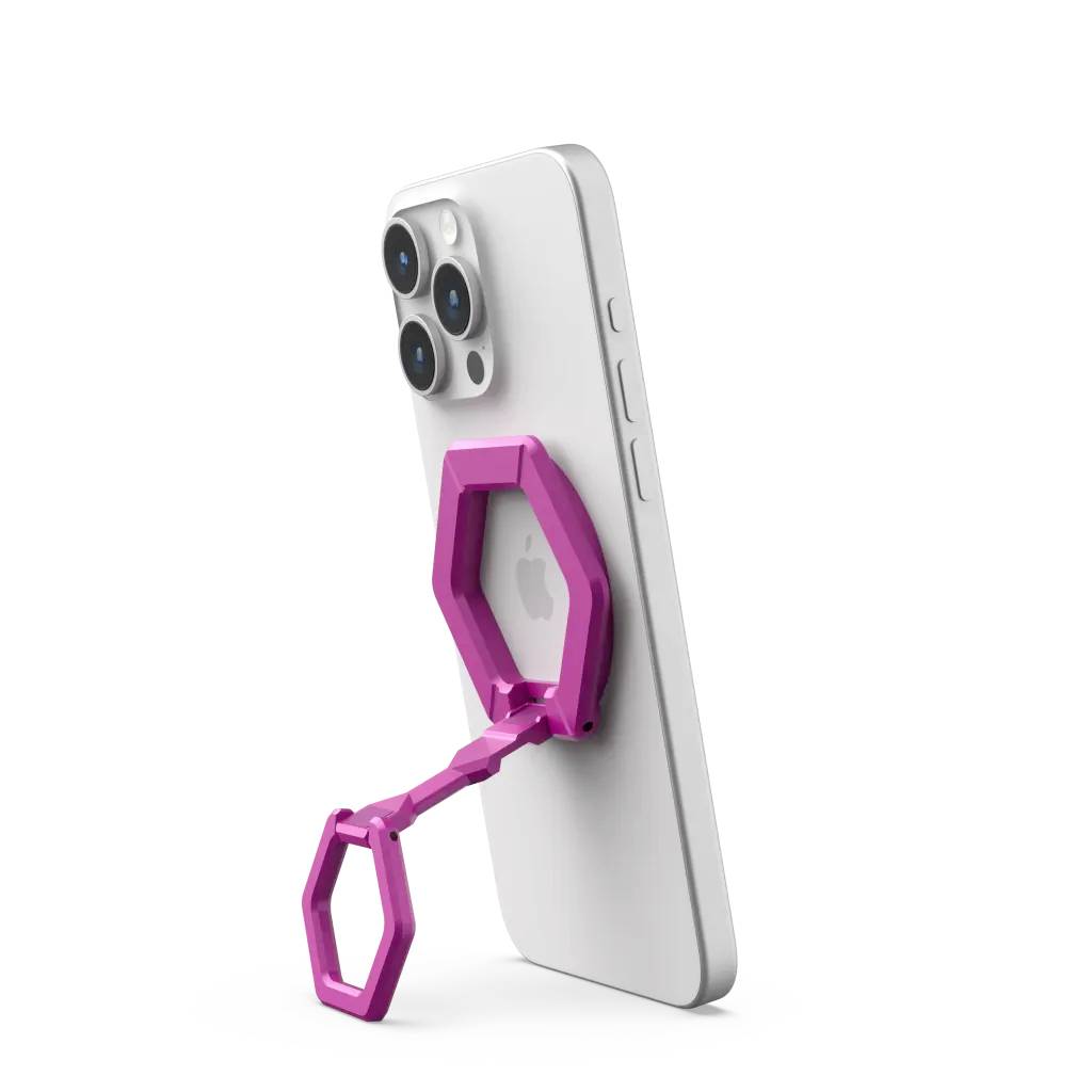 Różowy, składany uchwyt do telefonu podtrzymuje smartfona w pozycji pionowej. Uchwyt posiada strukturę plastra miodu i jest przymocowany do urządzenia.