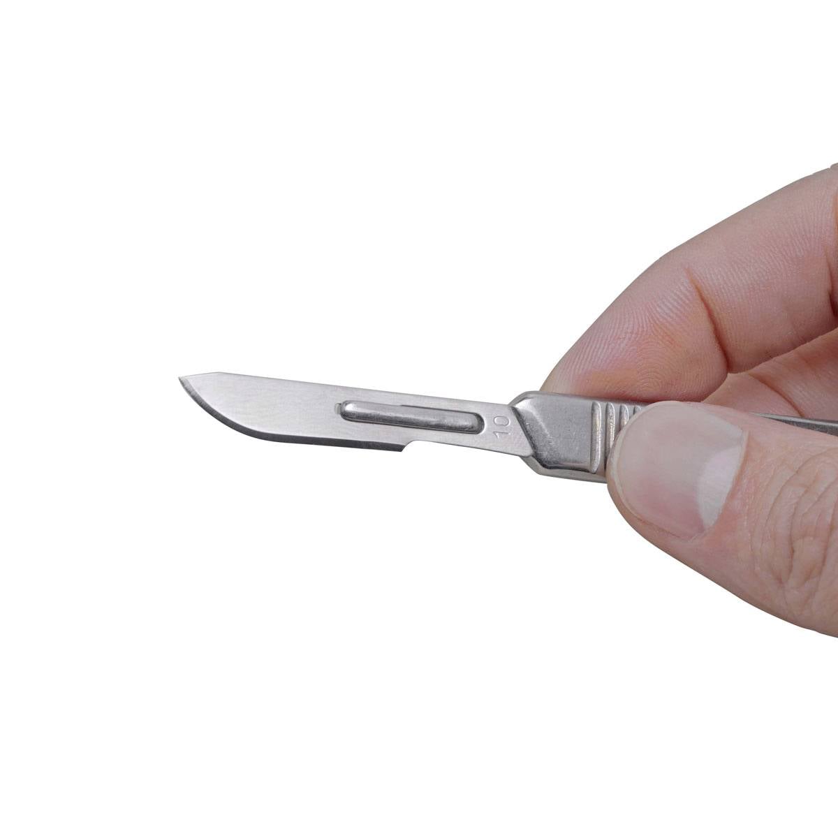 Dłoń trzyma chirurgiczny skalpel z ostrym ostrzem, gotowa do przeprowadzenia zabiegu medycznego.