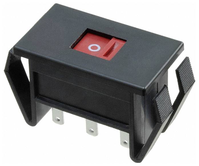 Prostokątny czarny włącznik bujany z czerwoną górą, posiadający biały symbol „O", wskazujący pozycję wyłączenia. Cztery metalowe bolce rozciągają się poniżej.