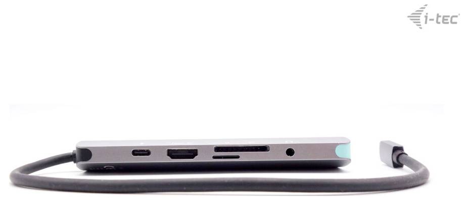 Płaski hub USB-C z wieloma portami, w tym HDMI, USB, czytnikiem kart i gniazdem audio. Podłączony przewodem.