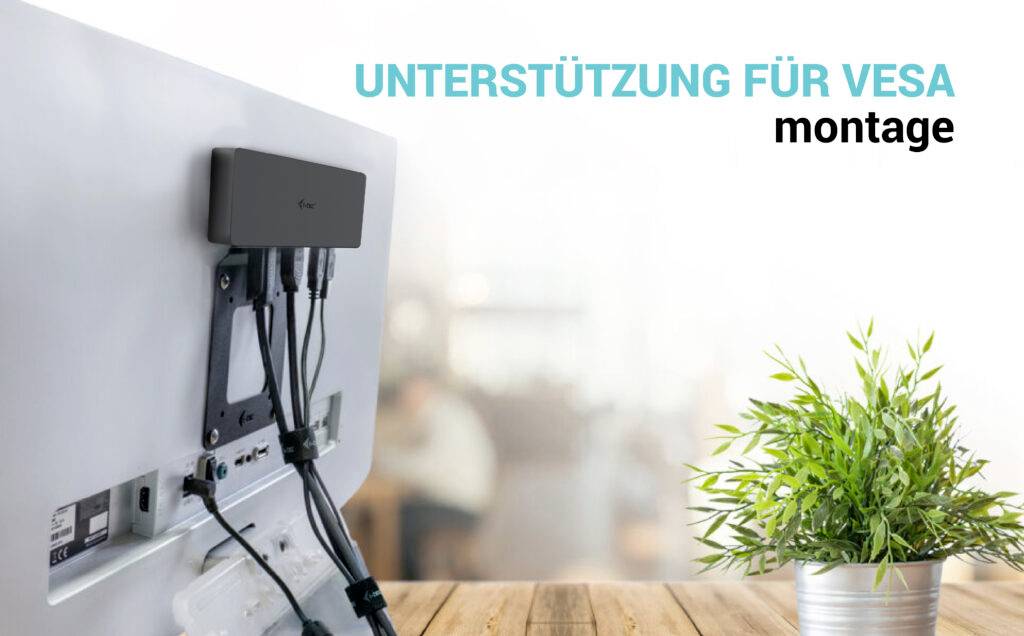 Wsparcie dla mocowania VESA: Monitor zamontowany na biurku za pomocą systemu mocowań VESA, obok którego stoi roślina.