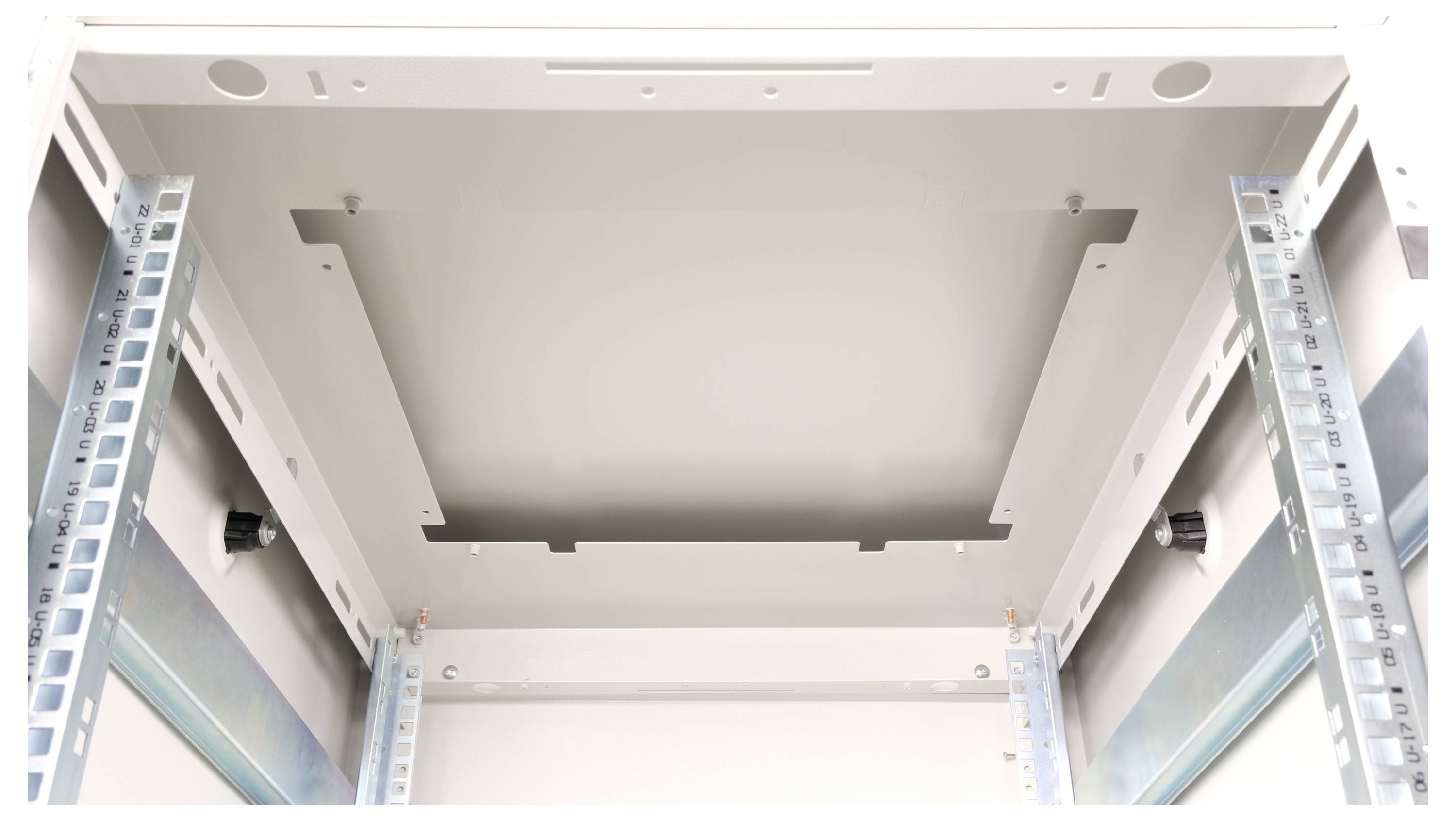 Widok wewnętrzny pustej szafy serwerowej z zamontowanymi szynami, gotowy do zainstalowania urządzeń.