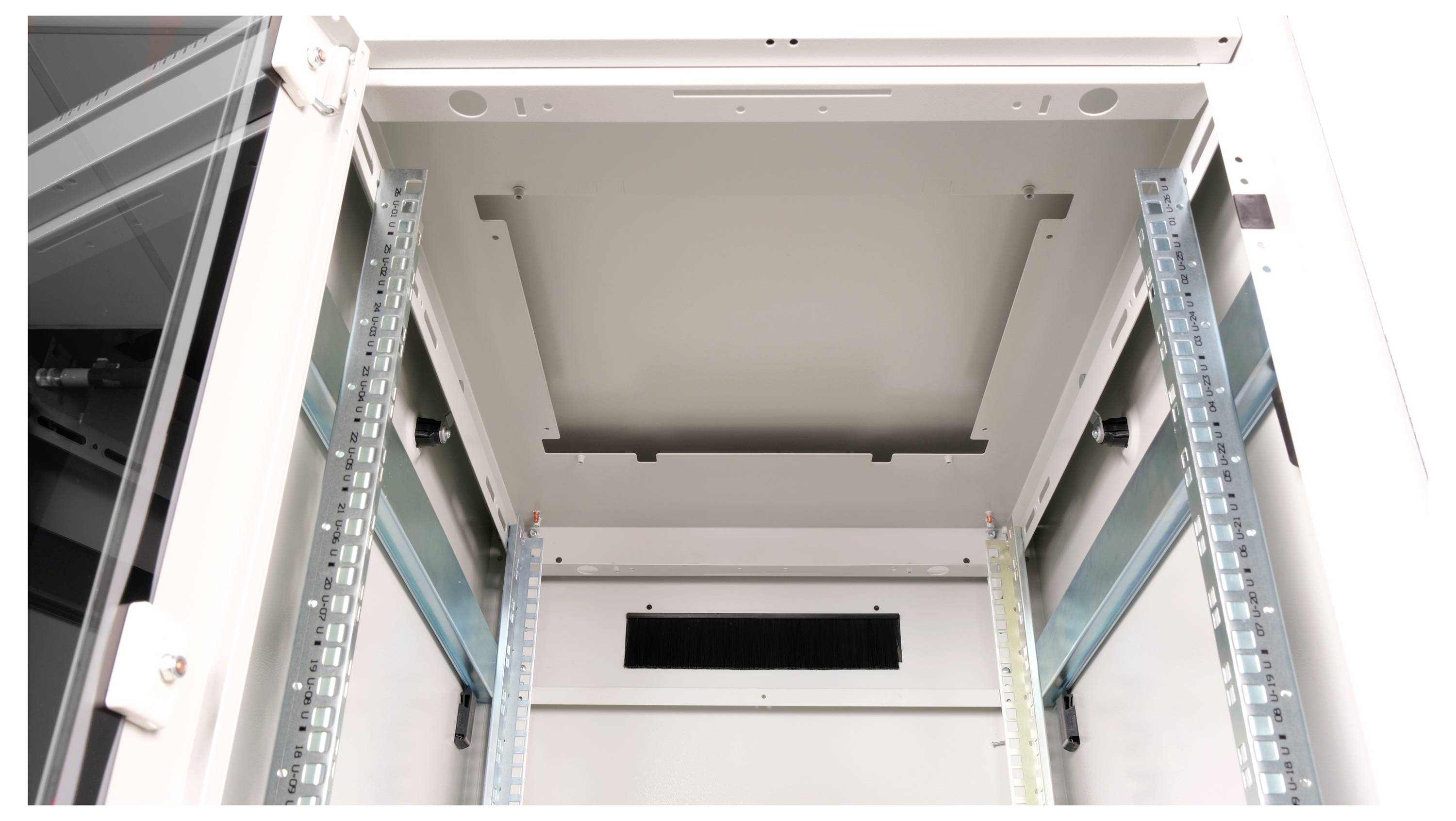 Widok wewnętrzny pustej szafy serwerowej z metalowymi szynami i otworami wentylacyjnymi, sfotografowany z perspektywy od dołu do góry.