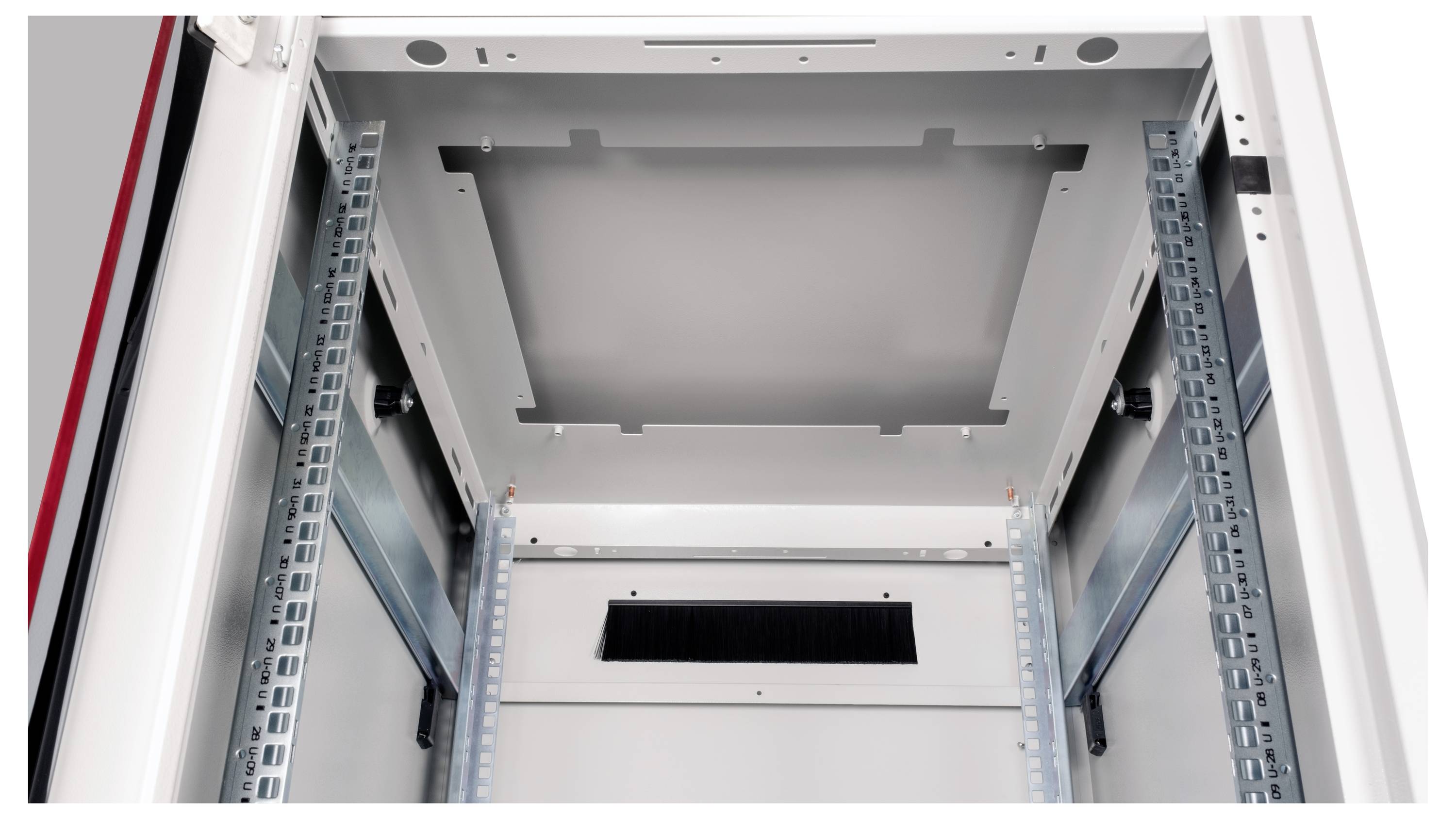 Widok wewnętrzny pustej metalowej obudowy z szynami po bokach do ewentualnego montażu elektroniki. Na górze znajduje się kratka wentylacyjna.