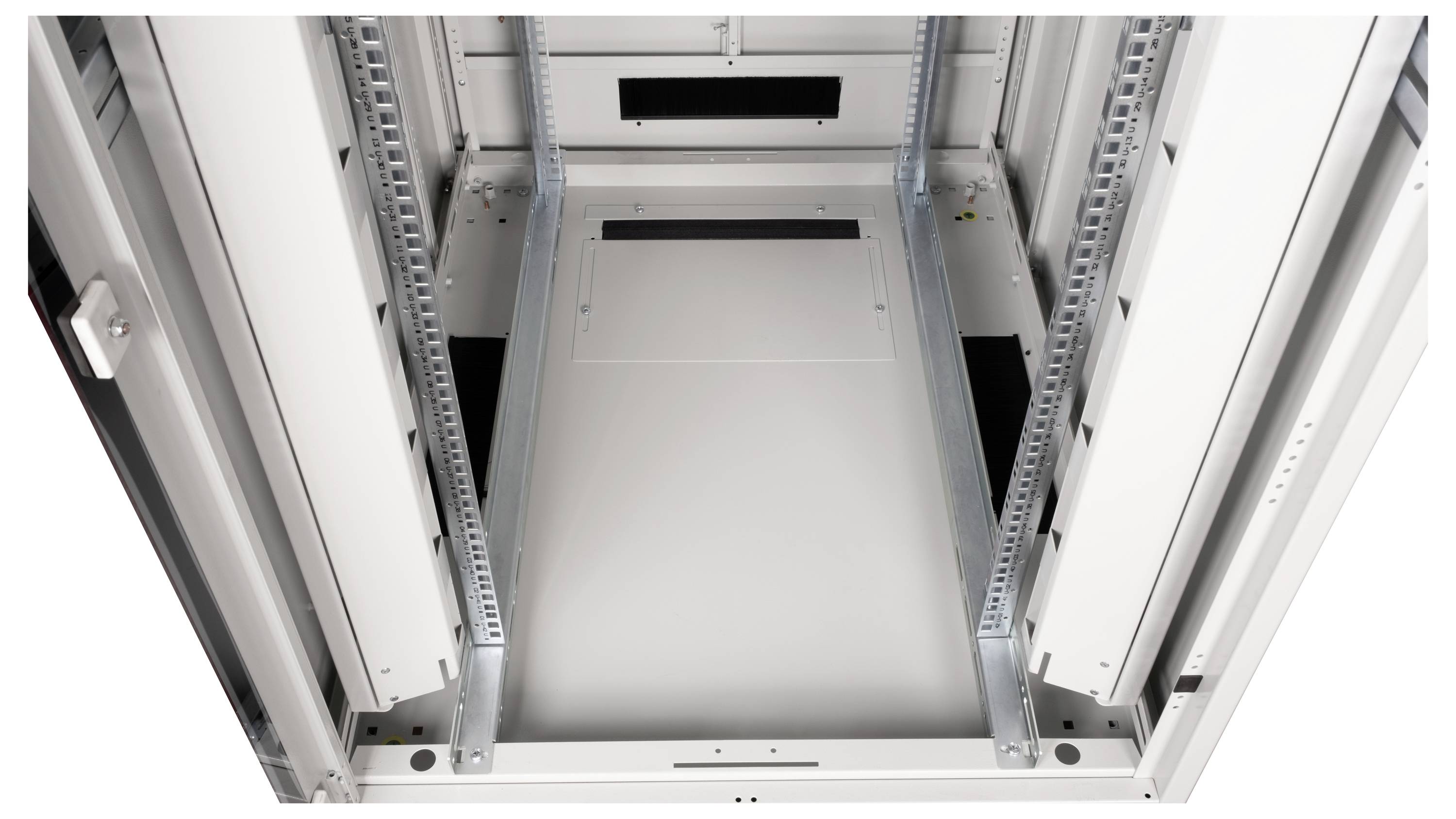 Widok wewnętrzny pustej szafy serwerowej z metalowymi szynami i kanałami kablowymi.