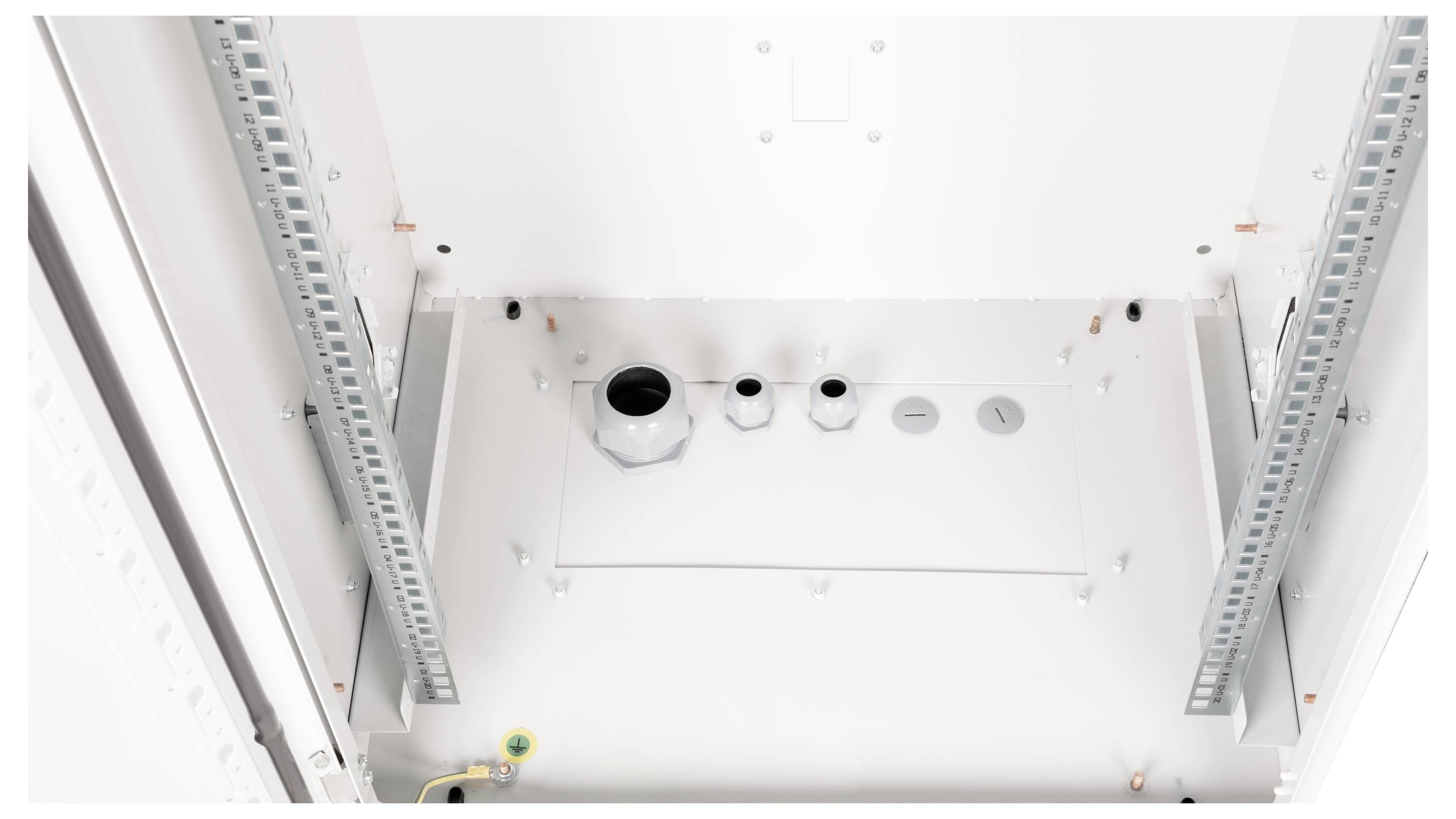 Biała metalowa skrzynka z kilkoma otworami o różnych rozmiarach w kształcie kół. Dwie metalowe szyny biegną pionowo wzdłuż boków.