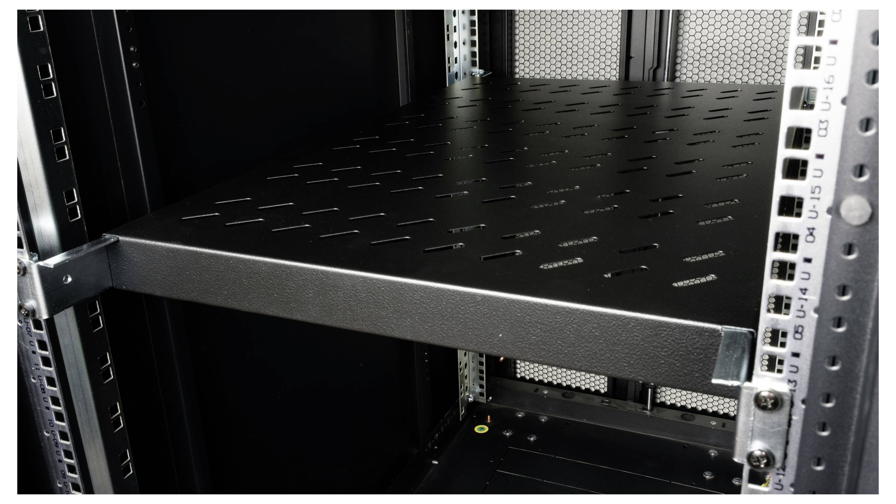 Pusty metalowy stojak serwerowy z perforowaną półką, gotowy do zainstalowania urządzeń informatycznych.