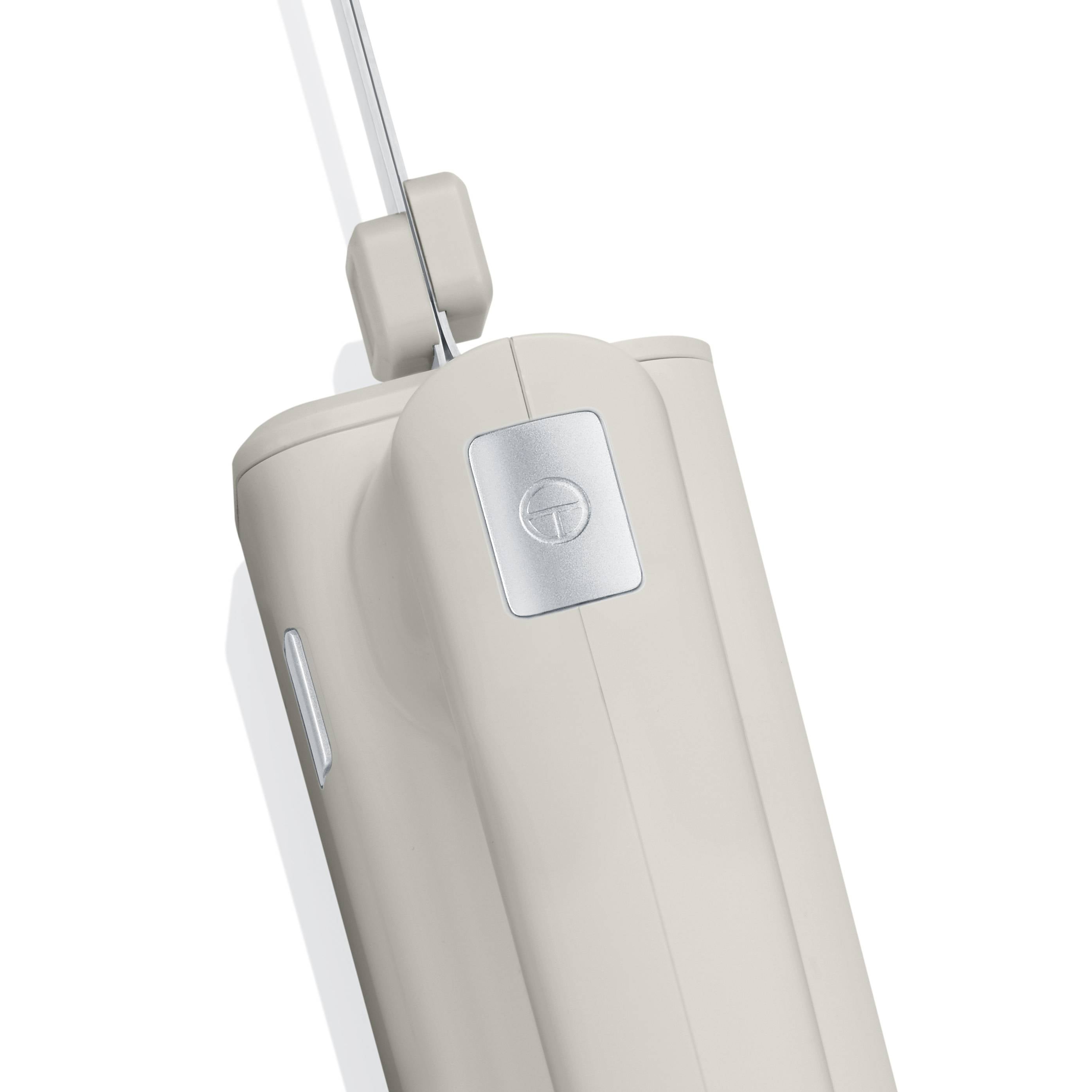 Biały, bezprzewodowy mikser ręczny z uchwytem i zdejmowanymi, chromowanymi trzepaczkami.