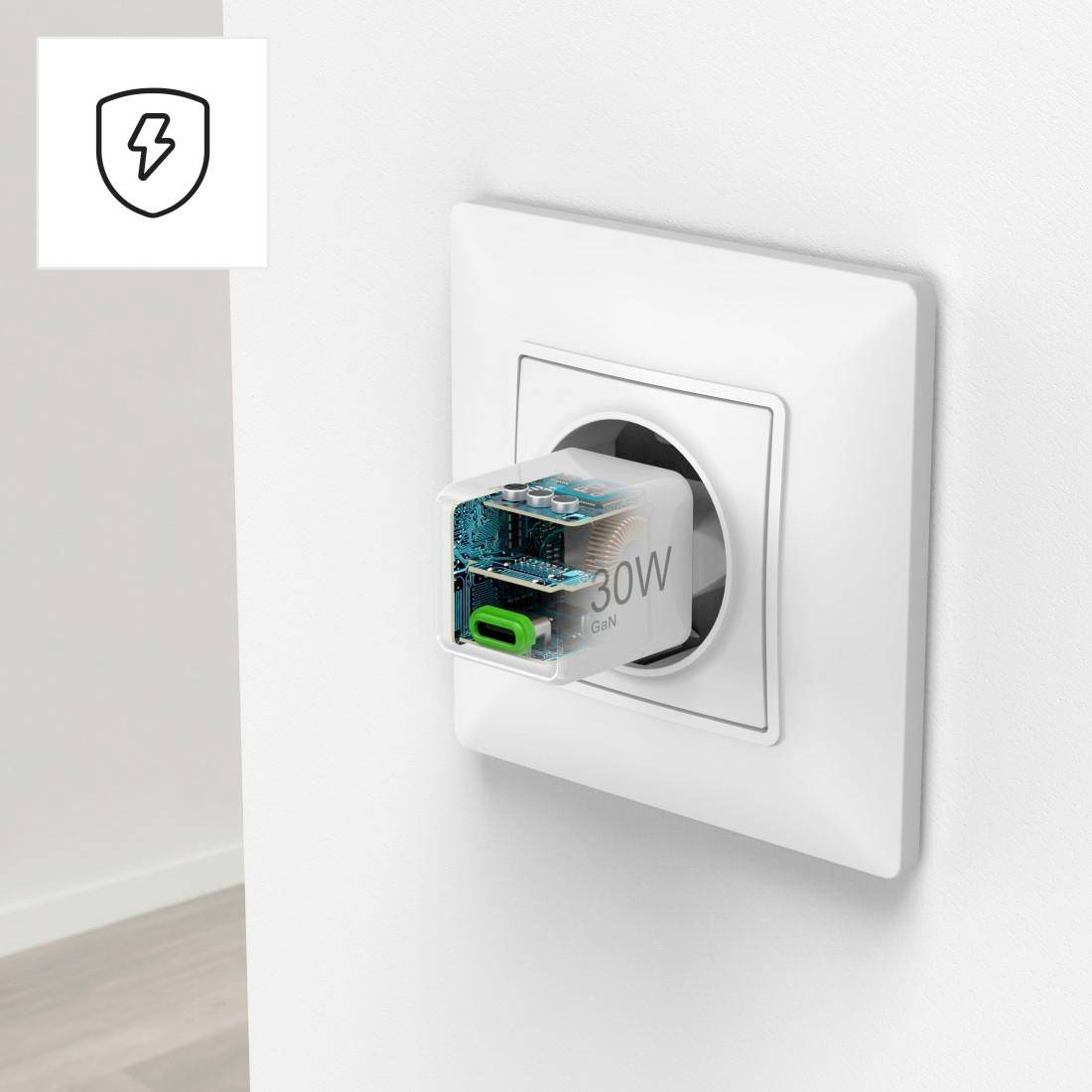 Nowoczesny adapter wtykowy jest włożony w gniazdko ścienne, ukazujący swą budowę techniczną poprzez przezroczyste obudowie. W lewym górnym rogu symbol błyskawicy.