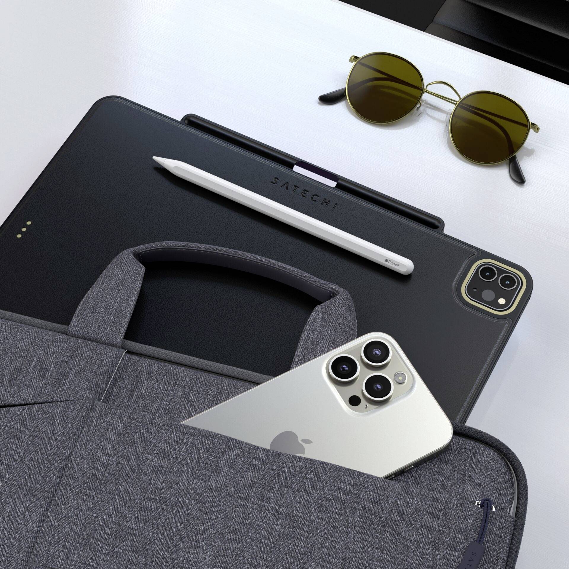 Tablet z rysikiem, okulary przeciwsłoneczne i smartfon leżą na stole. Wszystkie przedmioty są nowocześnie zaprojektowane i utrzymane w eleganckich odcieniach kolorów.