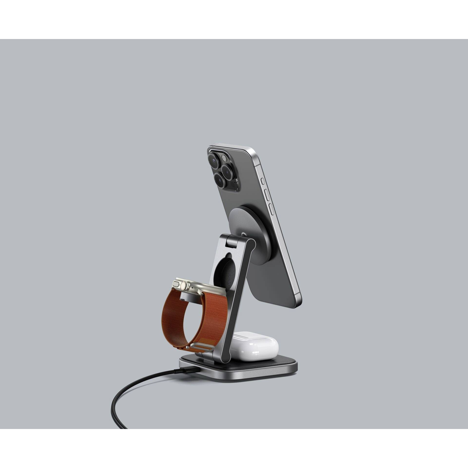 Bezprzewodowy zestaw ładujący z telefonem, strefą ładowania smartwatcha i słuchawkami AirPods, stylowo prezentowany na srebrnym stojaku.