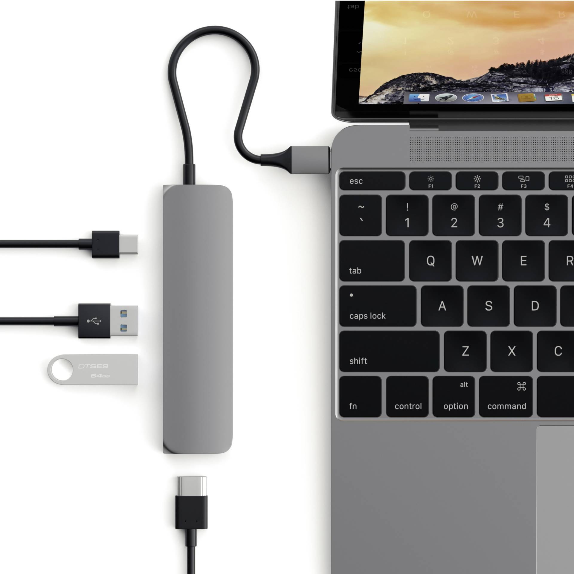Laptop z podłączonym hubem USB, prezentujący różne podłączone adaptery i kable na biurku.