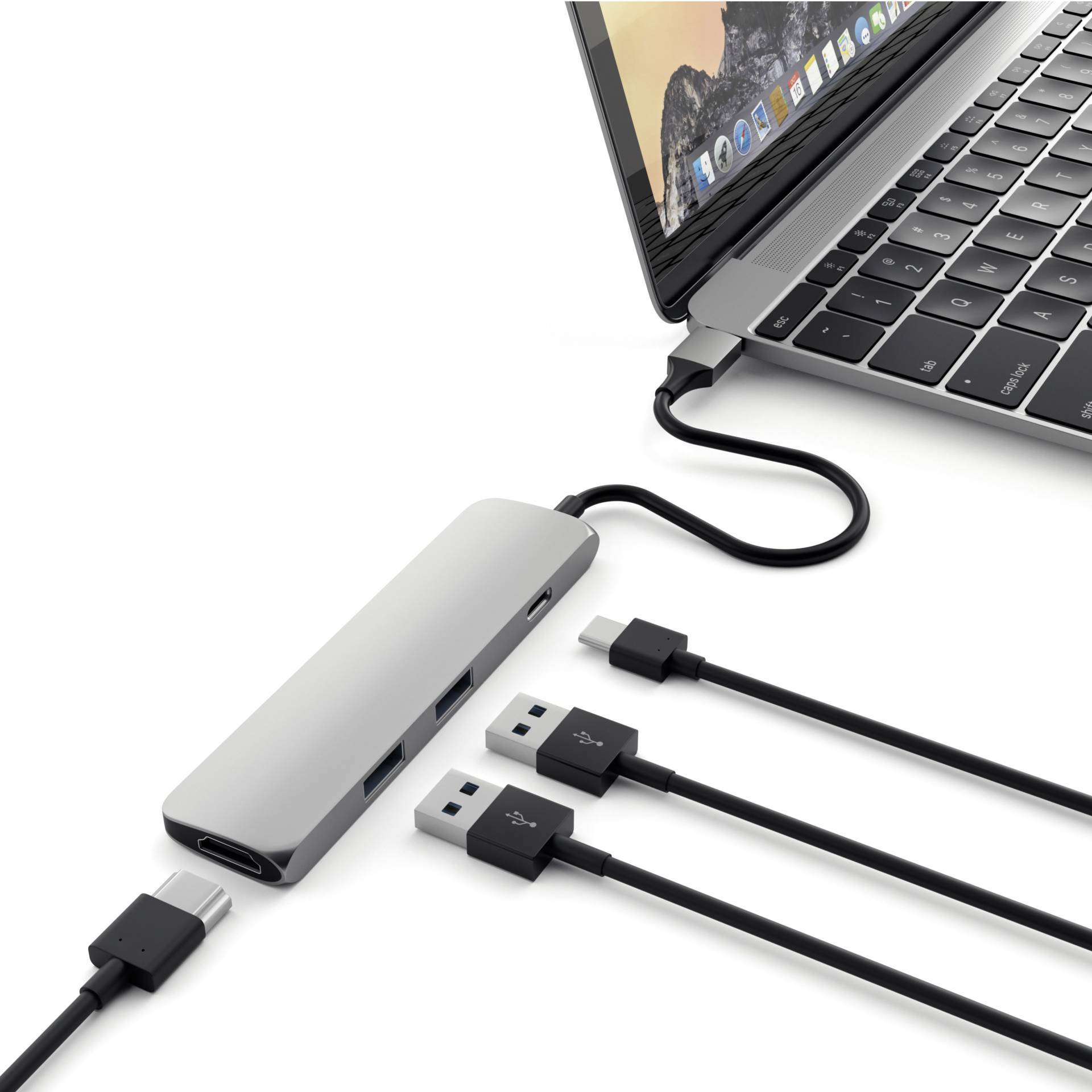 Laptop z adapterem USB-C podłączonym z boku. Adapter posiada kilka portów USB z podłączonymi kablami.