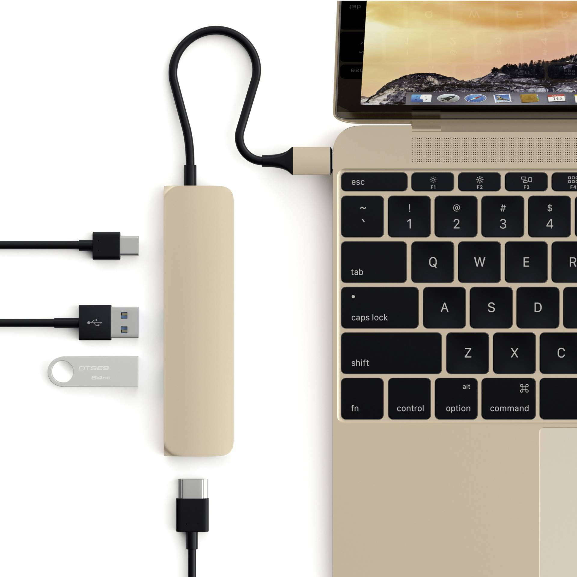 Złoty laptop po prawej stronie, obok niego hub USB-C z wieloma portami. Prezentuje połączenia dla USB, HDMI i kart SD, przydatny do podłączania dodatkowych urządzeń peryferyjnych.