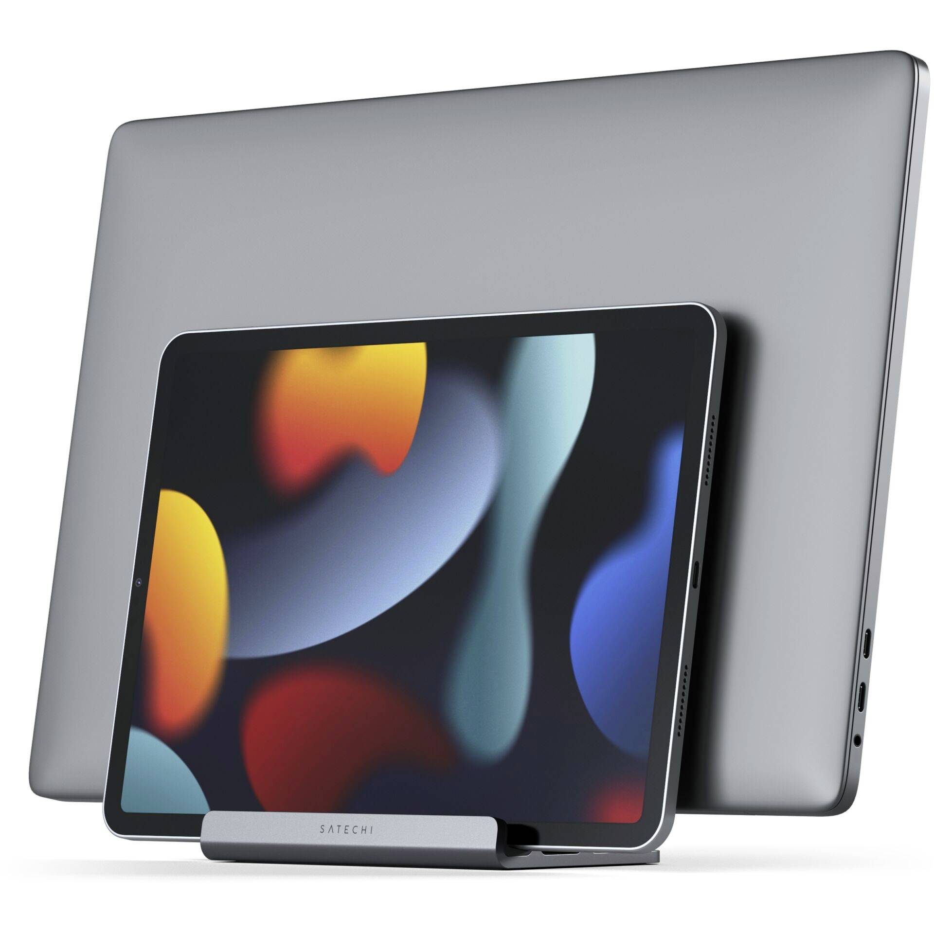 Tablet stoi w uchwycie przed laptopem. Oba urządzenia mają nowoczesny, smukły wygląd.